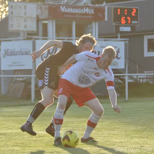 Löftadalens spelande tränare Hallengärd täcker bollen bra för Åsa IFs Martin Larsson