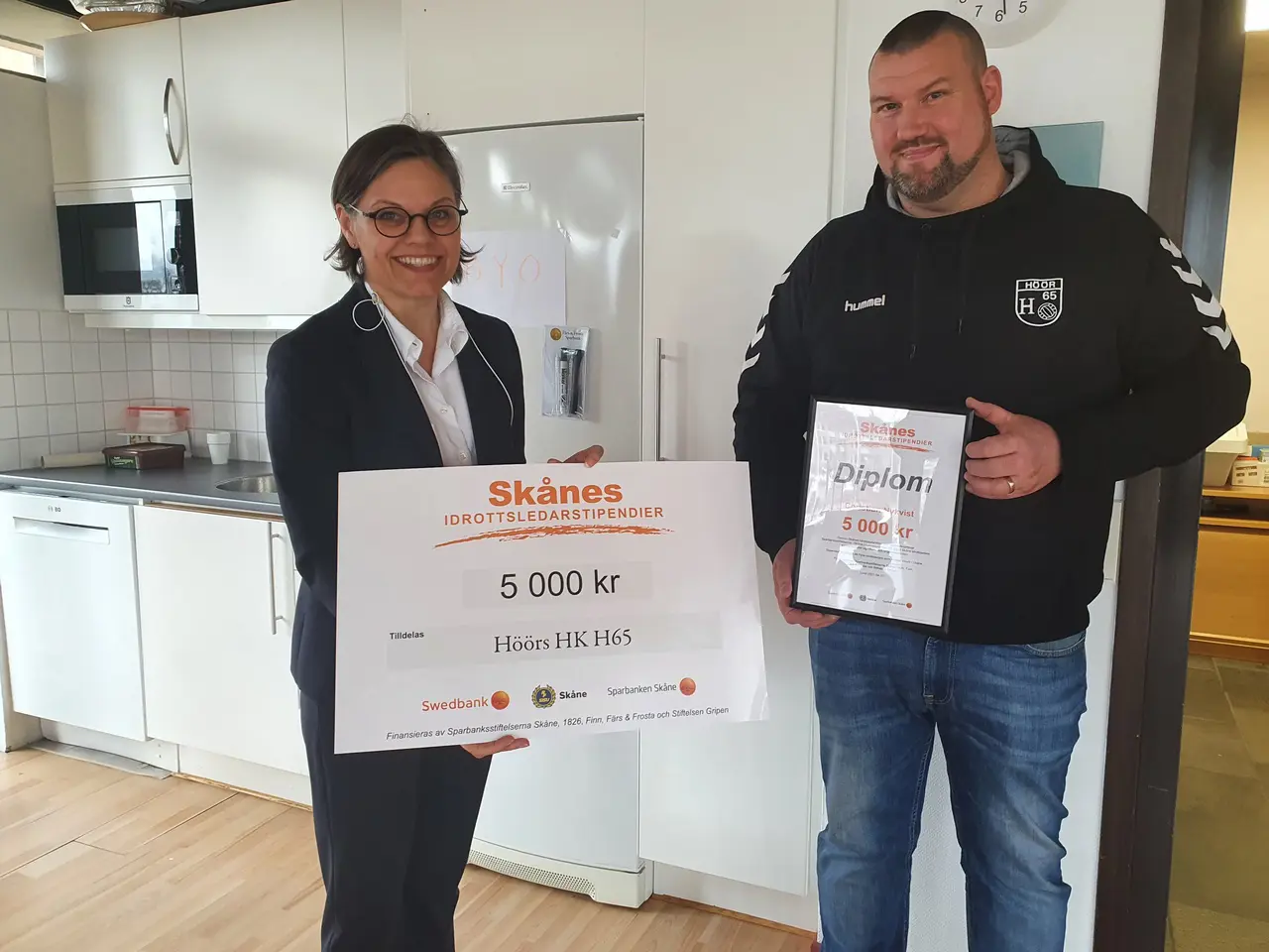 Christian mottar priset från Maria Pehrson från Sparbanken Skåne