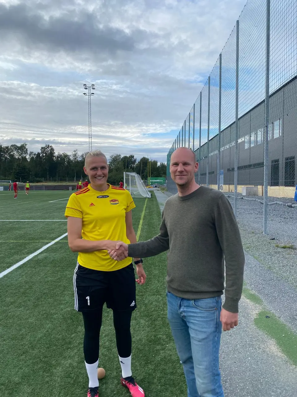 Karolina Sundberg skakar hand med Sportchef Jeppe Mauritzson efter det påskrivna avtalet.