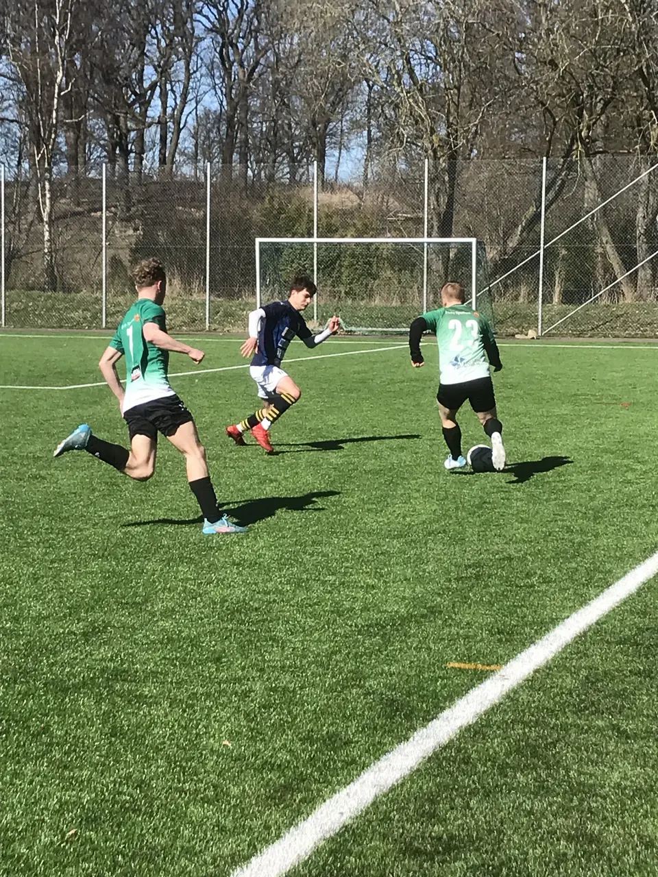 Kenny med bollen, Elliot kommer på utsidan.