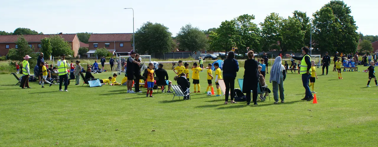 Bild från Çok Najs Cup 2024 med matchvärdar i gröna västar. Konerna markerade gränsen för publiken.