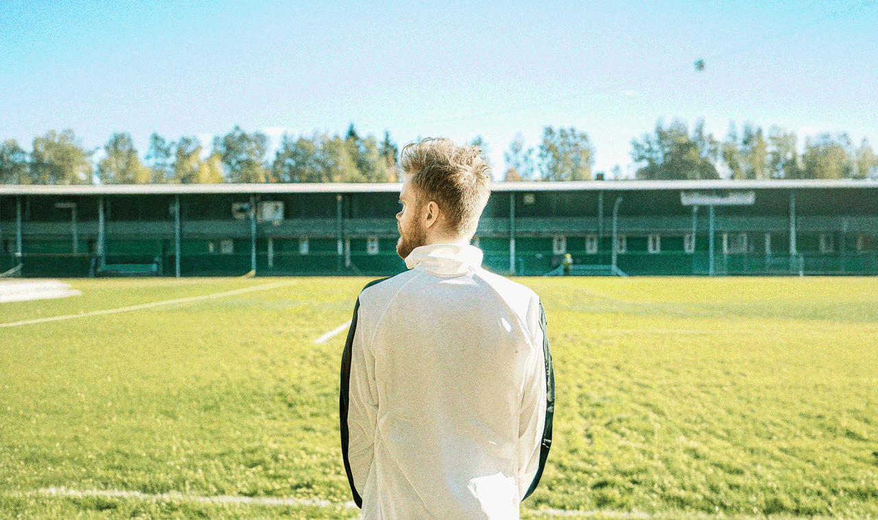Person på fotbollsplan blickar ut över planen inför match.
