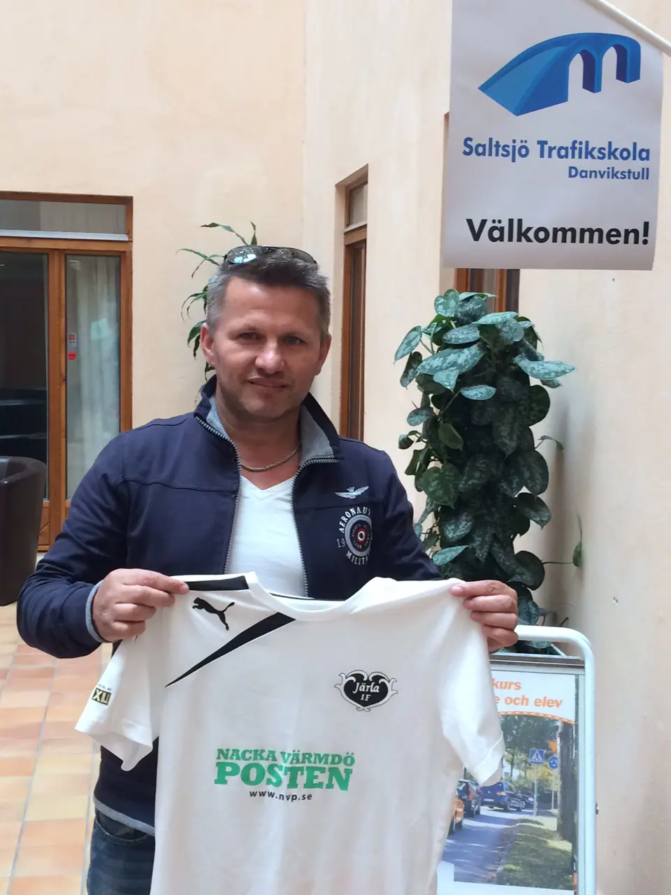 Trafikskolechef Aleksander Ndoja håller upp Stockholms vackraste fotbollströja!