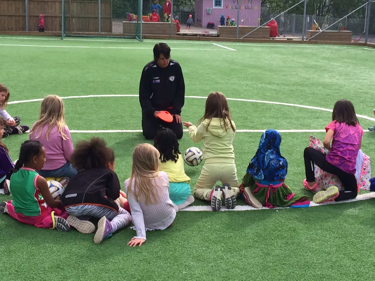 Camilla Norström instruerar ett gäng glada fotbollstjejer!