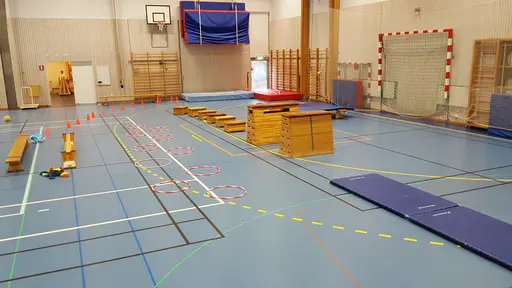 Hinderbanan i sitt grundutförande. Till höger är det en bom som barnen ska slå en boll över, och till vänster (där fotografen står) ska man fånga och kasta tillbaka en boll till en ledare.